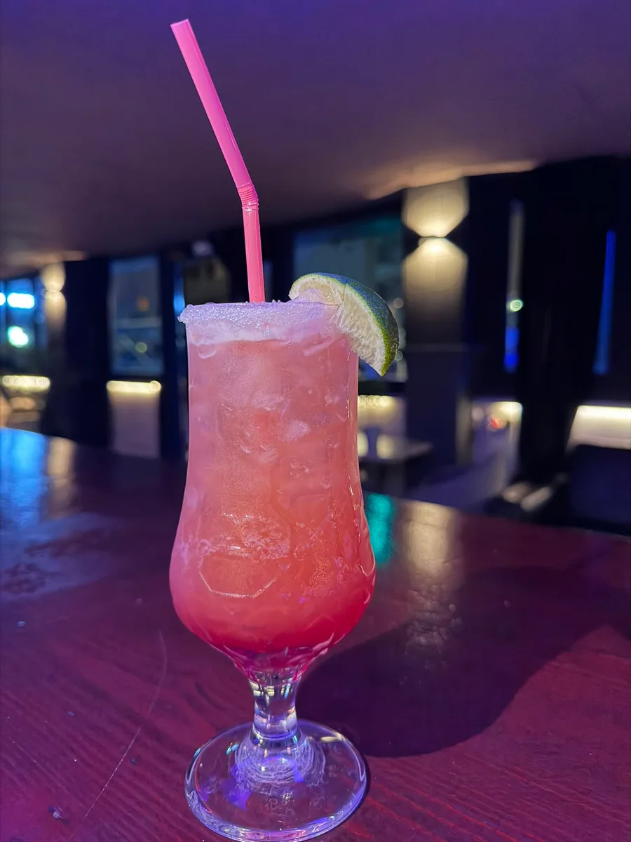 Pink cocktail with ice and a lime garnish served at Boulevard Gandia